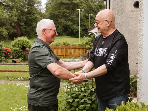 Taxi driver Brian Kelly, left, shaking hands with Prostate Cancer UK volunteer Tam Hewitt in Glasgow