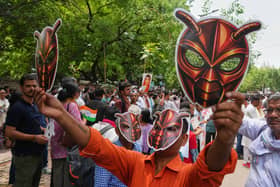 Supporters wear and display cockroach masks during a protest in New Delhi, India