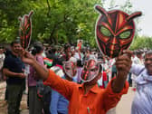 Supporters wear and display cockroach masks during a protest in New Delhi, India