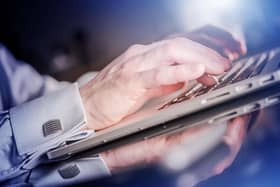 Man's hands typing on a laptop keyboard