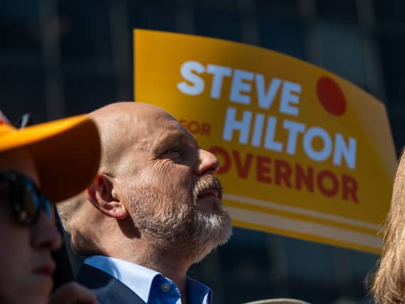 Steve Hilton in front of campaign placards