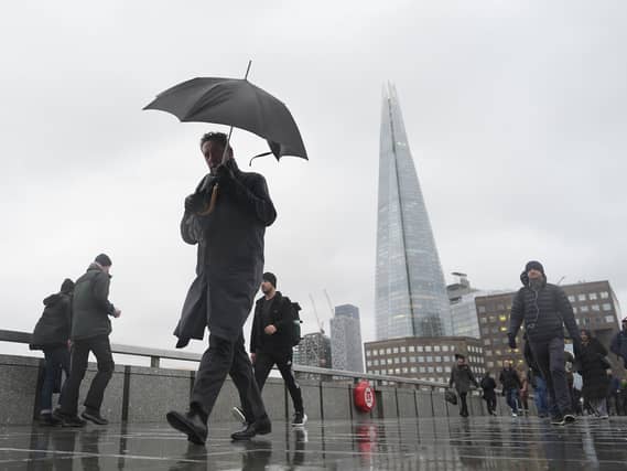 A person walking holding an umbrella