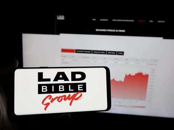 A mobile phone with the logo of British media company Ladbible Group Limited on screen in front of web page.