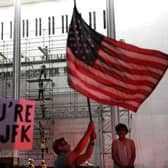 People wait for President Donald Trump’s name to be removed