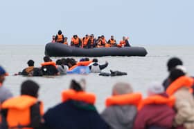 People in life jackets in boats at sea