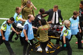 Canada head coach Jesse Marsch consoles Ismael Kone as he is carried off the field on a stretcher in the 6-0 World Cup win over Qatar