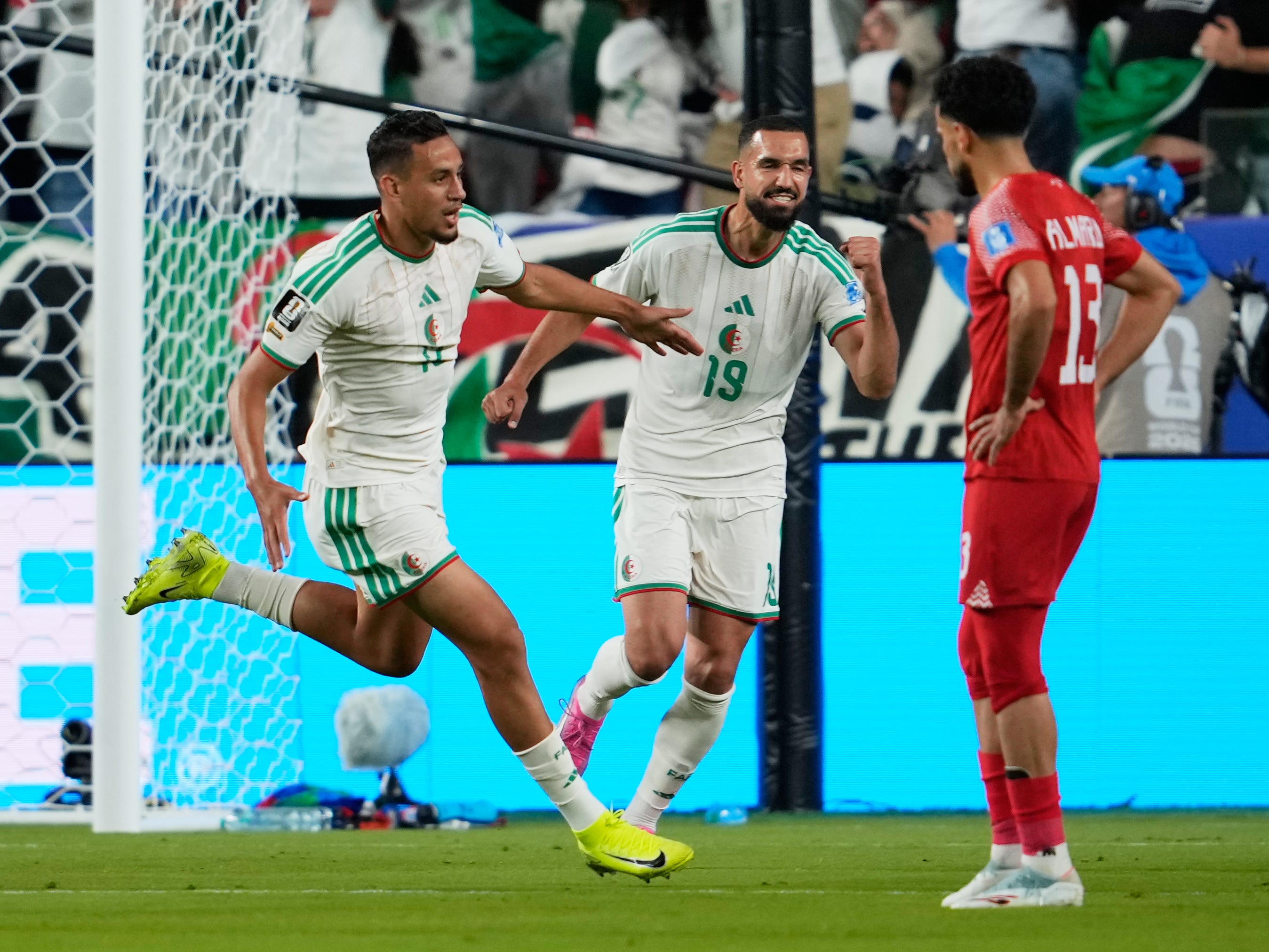 Algeria’s Nadhir Benbouali, left, celebrates after scoring his side’s opening goal
