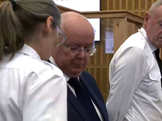 Peter Murrell flanked by security officers in court