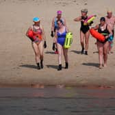 Swimmers heading to the water at Cullercoats Bay