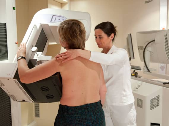 A woman undergoes breast screening