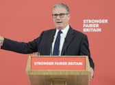 Sir Keir Starmer pointing while speaking in front of signage that reads 'Stronger fairer Britain'