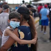 A mother and child wait in line for government humanitarian aid, days after an earthquake struck in La Guaira, Venezuela