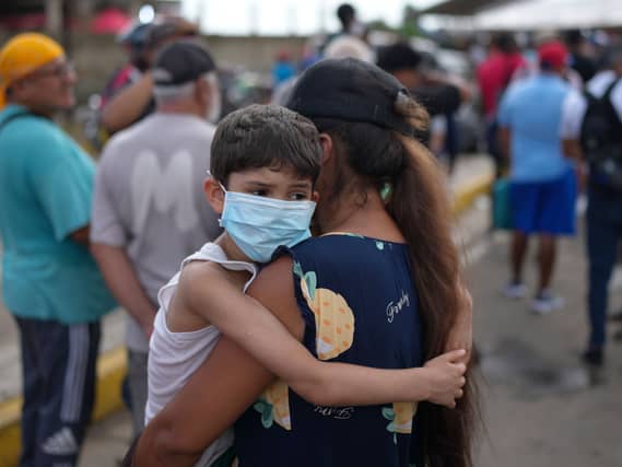 A mother and child wait in line for government humanitarian aid, days after an earthquake struck in La Guaira, Venezuela