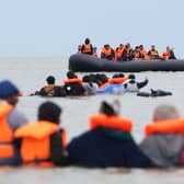 People wearing orange lifejackets in small boats at sea