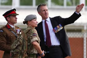 Defence Secretary Dan Jarvis, wearing a suit, speaks to two soldiers