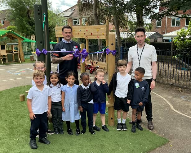 Darts star Luke Woodhouse, headteacher Lee Davis-Powell and some of early years children at Claregate Primary School