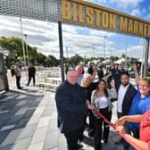 Trader Julie Emery cuts the ribbon of the new Bilston Market, with council leader Stephen Simkins, trader Andrew Pritchard, Councillors Linda Leach, Leigh New and Qaizer Aseem, and market manager Jo Huntsbach in blue