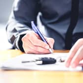 Man signing loan for car