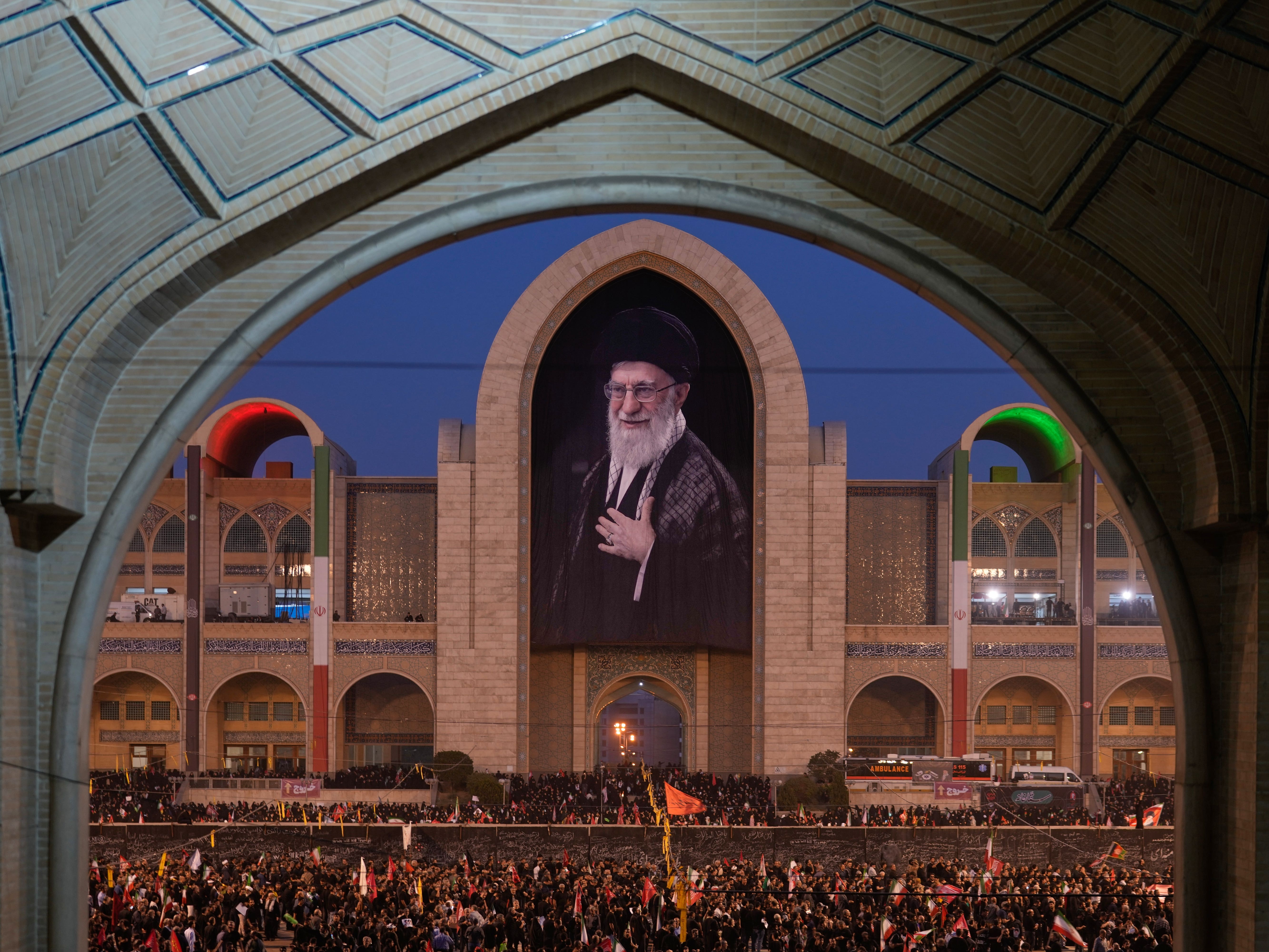 Mourners gather beneath a portrait of the late Iranian Supreme Leader Ayatollah Ali Khamenei during the funeral ceremonies in Tehran
