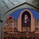 Mourners gather beneath a portrait of the late Iranian Supreme Leader Ayatollah Ali Khamenei during the funeral ceremonies in Tehran