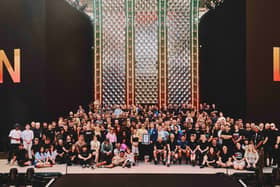 Harry Styles holding his Guinness World Records certificate on stage surrounded by members of his team