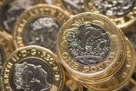 Pound coins sit in a pile