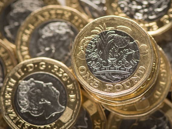 Pound coins sit in a pile