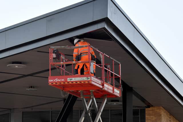  A workman installing the canopy ceiling and lighting at the new Dudley bus station