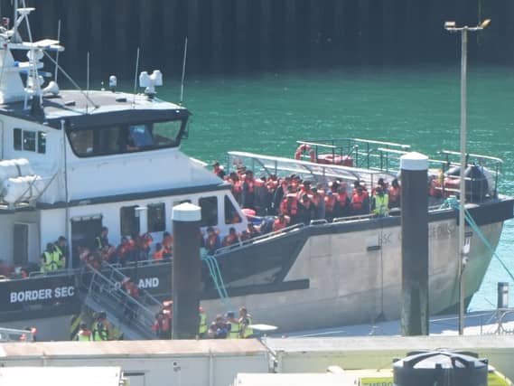 People in life jackets disembarking a boat in port