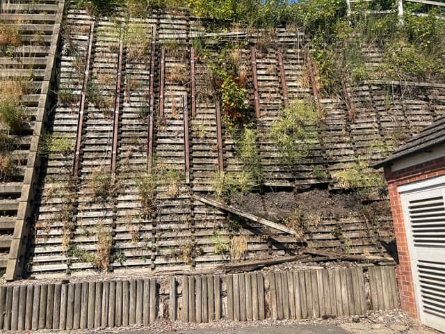 The wooden wall behind the Goodrich Mews estate is visibly falling into disrepair