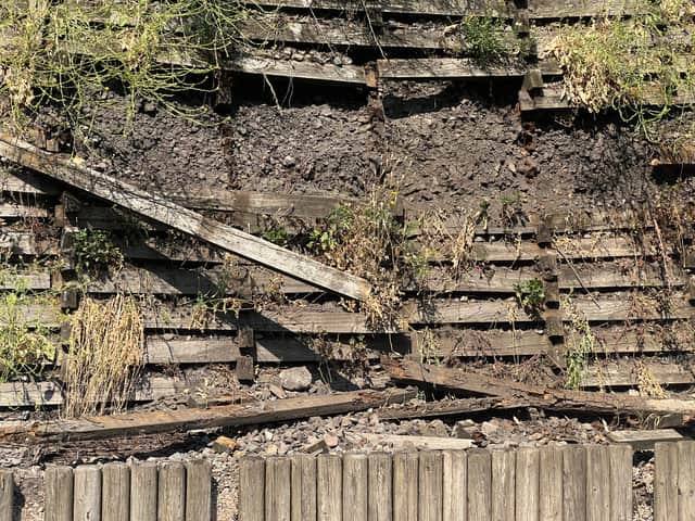 The wooden wall behind the Goodrich Mews estate is visibly falling into disrepair