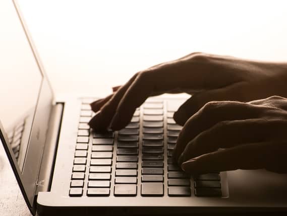 A woman’s hands on a laptop keyboard.