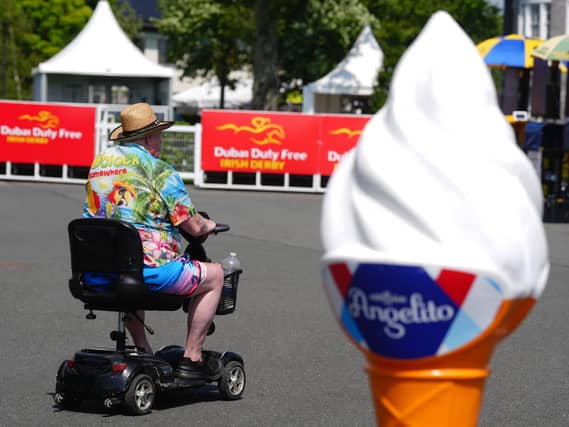A racegoer passes by an ice cream advertising cone at the Curragh Racecourse in Curragh in Co Kildare