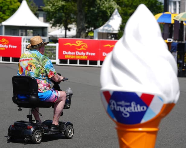 A racegoer passes by an ice cream advertising cone at the Curragh Racecourse in Curragh in Co Kildare