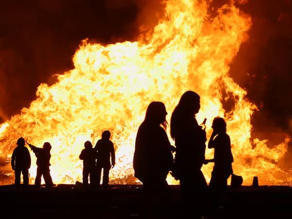 Battle of the Boyne bonfires with people sillouhetted in front