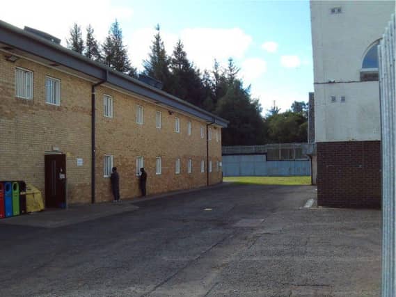 Male detainees looking through the windows of the female unit at Dungavel immigration removal centre in South Lanarkshire