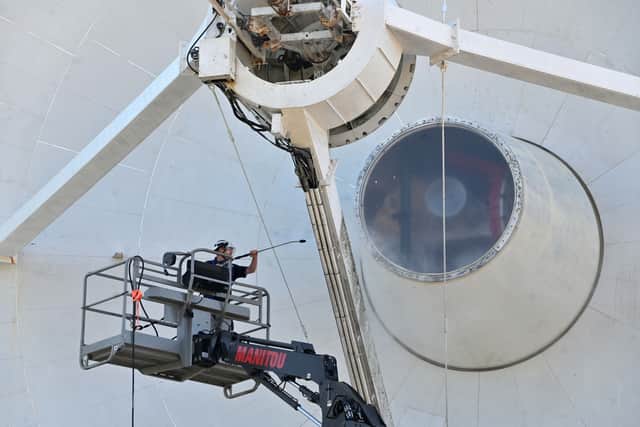 Workers giving the radio telescope a jet wash.