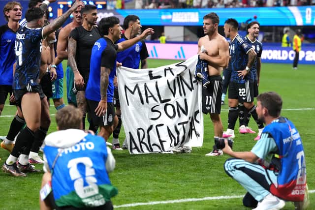 Argentina players hold a banner on the pitch