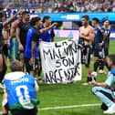 Argentina players hold a banner on the pitch
