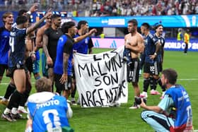 Argentina players hold a banner on the pitch