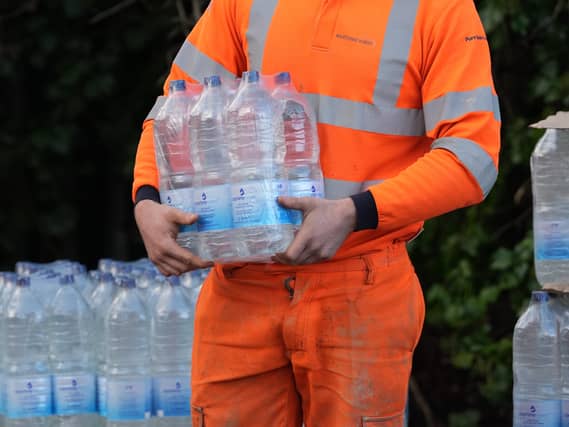 A worker hands out bottled water at the Tunbridge Wells Sports Centre