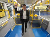 Andy Burnham standing on a bus