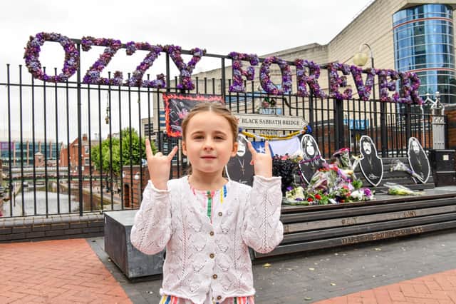 Eliza Handley, six, remembers laying flowers at the Black Sabbath Bench on Broad Street only a year ago, as she looks at the tributes on Ozzy Day