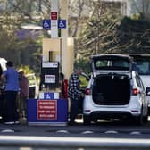 People dispense fuel at the pump at Costco Petrol Station in West Thurrock, Essex