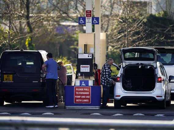 People dispense fuel at the pump at Costco Petrol Station in West Thurrock, Essex