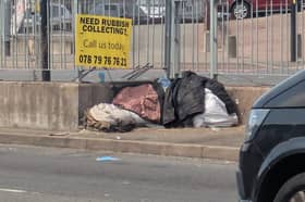 The yellow board advertising a waste collection service has been fixed to railings on Newton Road