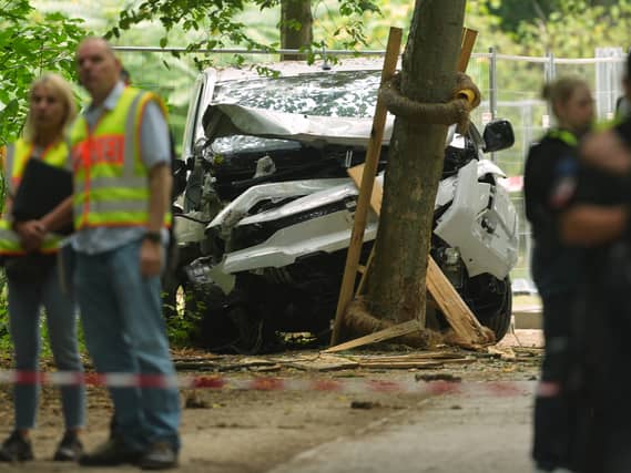 Police near a vehicle crashed into a tree in Berlin