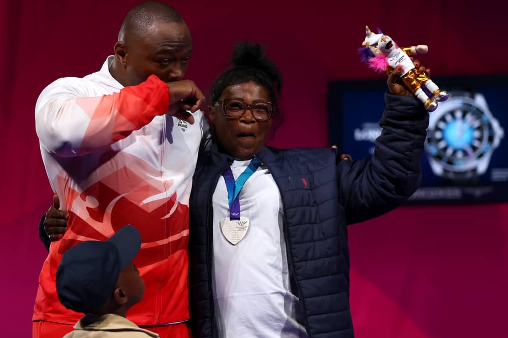 Silver medalist Cyrille Tchatchet II celebrates with his mother during the medal ceremony for the men's 110kg weightlifting on day seven of the Glasgow 2026 Commonwealth Games at SEC Armadillo