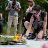 A woman places flowers at the scene