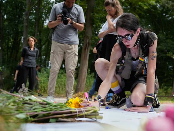 A woman places flowers at the scene